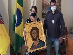 duas pessoas segurando um quadro da obra